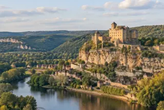 Château de Beynac dominant la vallée boisée de la Dordogne sous une lumière douce de fin d’après-midi.